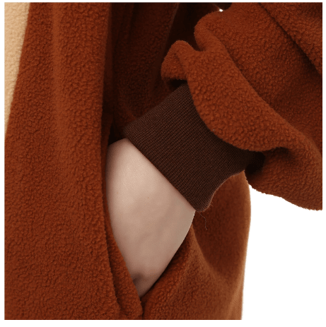 Close-up of the fleecy brown fabric, a hand in the side pocket and a ribbed cuff