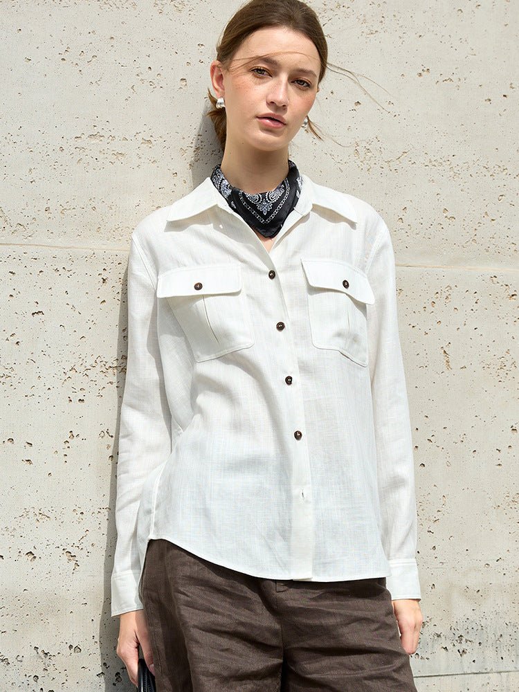 Witte blouse met donkerbruine knopen, los gedragen met een marineblauw sjaaltje