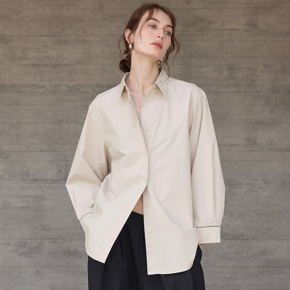 Relaxed long-sleeve shirt with dropped shoulder in beige, worn by a model, front view, slightly unbuttoned