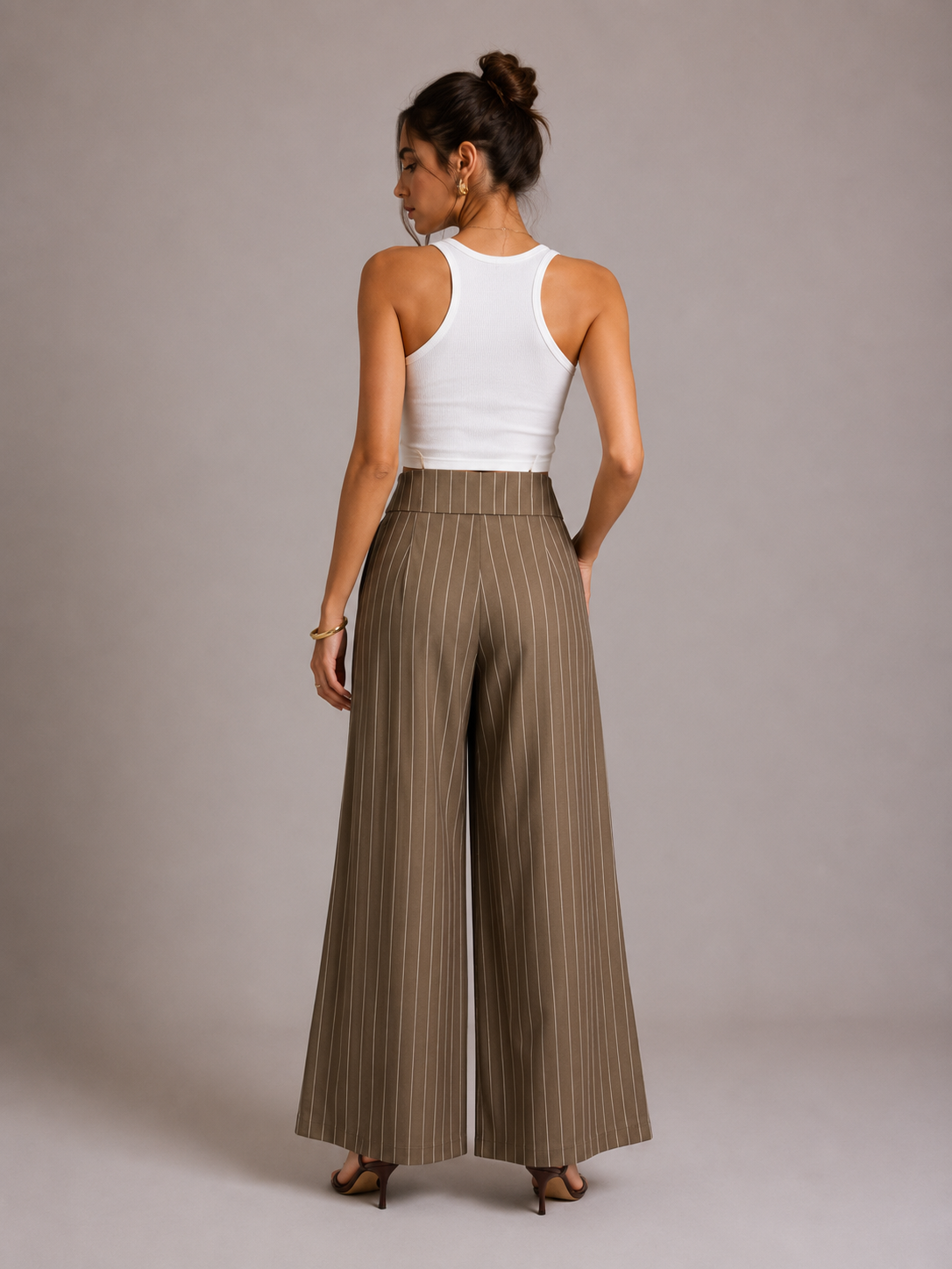 Back view of brown pinstripe wide-leg trousers on model, showing plain back and flat waistband