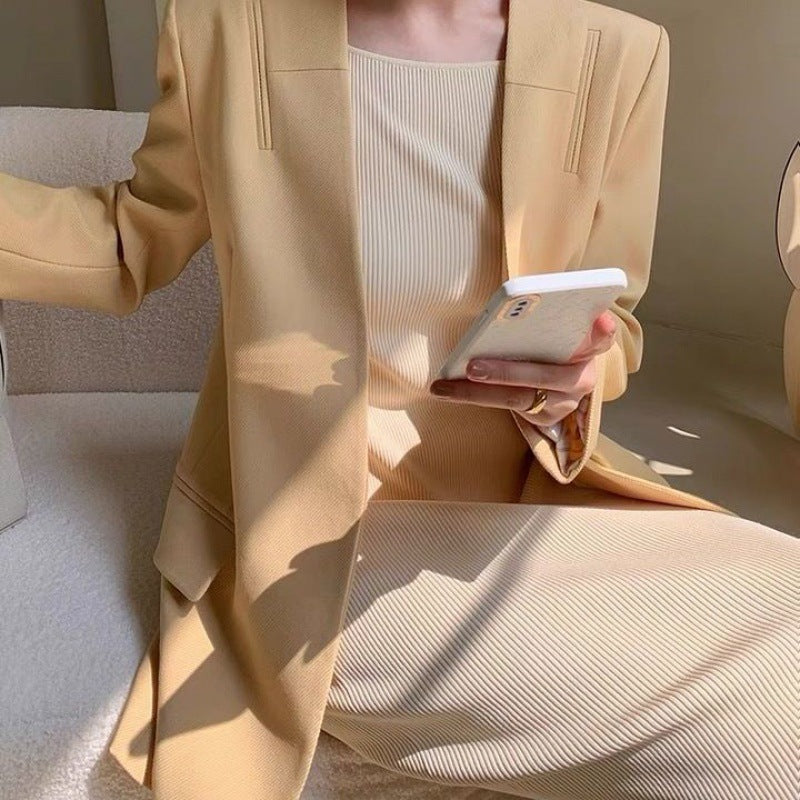 Ribbed-knit cami midi dress in apricot worn under beige blazer, front view on model holding phone