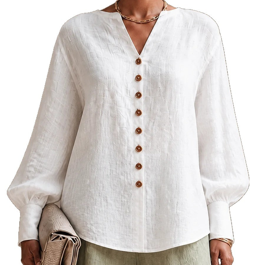 Close-up of white V-neck lantern-sleeve blouse with wood-tone buttons, front view