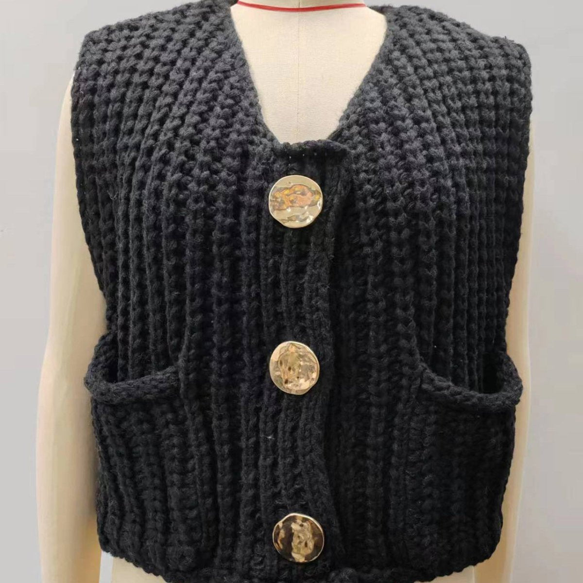 Chunky knit vest in black with gold-tone buttons and patch pockets