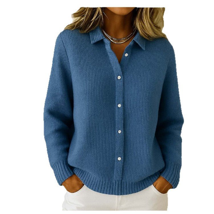 Dark blue collared sweater with white buttons, worn with white trousers