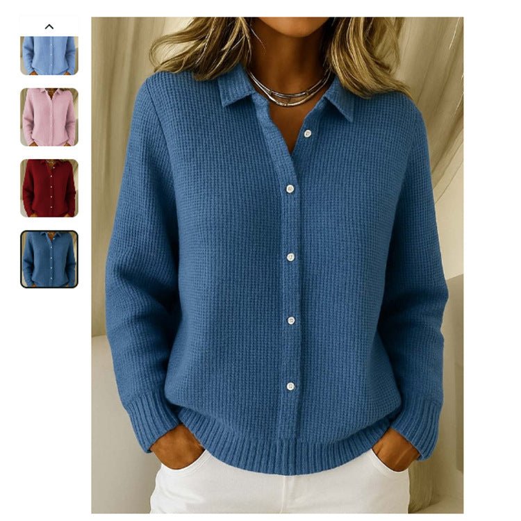 Dark blue button-front sweater, hands in the pockets of white trousers