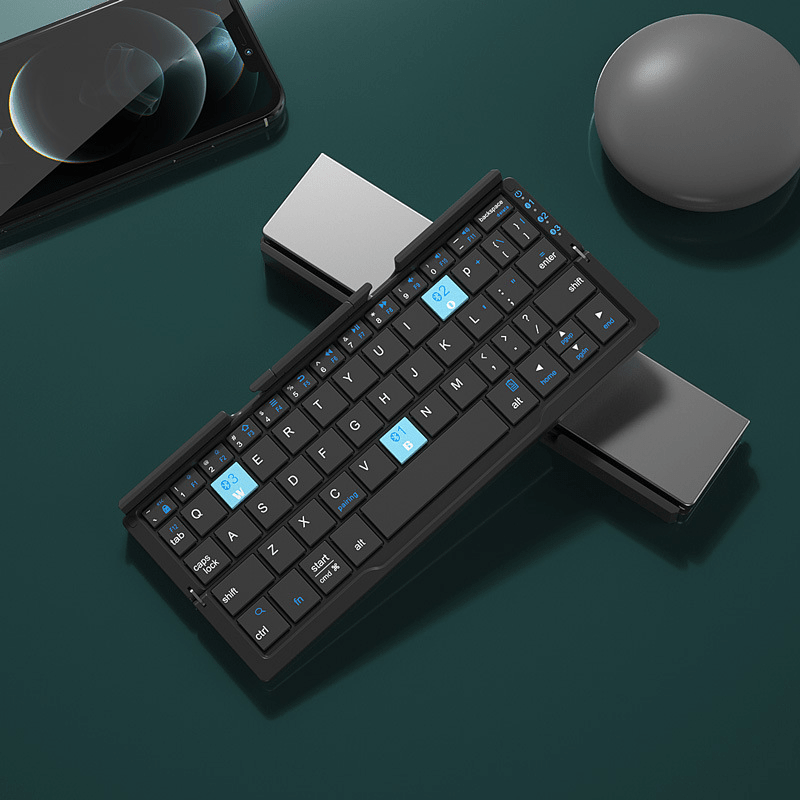 Black 60-key folding keyboard next to a phone and a round grey object