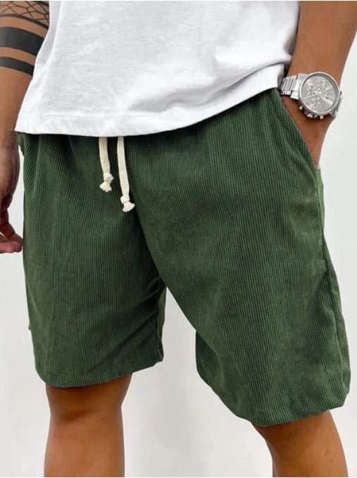 Dark green corduroy shorts, hand in the side pocket