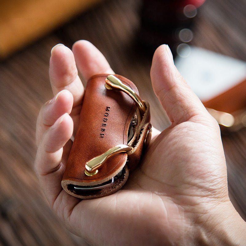 Brown key organiser lying in an open hand, about as long as the palm