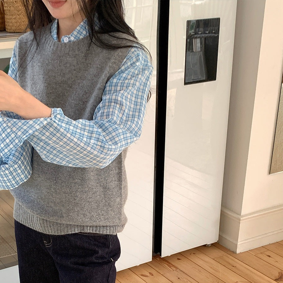 Lichtgrijze wollen gebreide gilet met cashmere gedragen over een blauw geruit overhemd