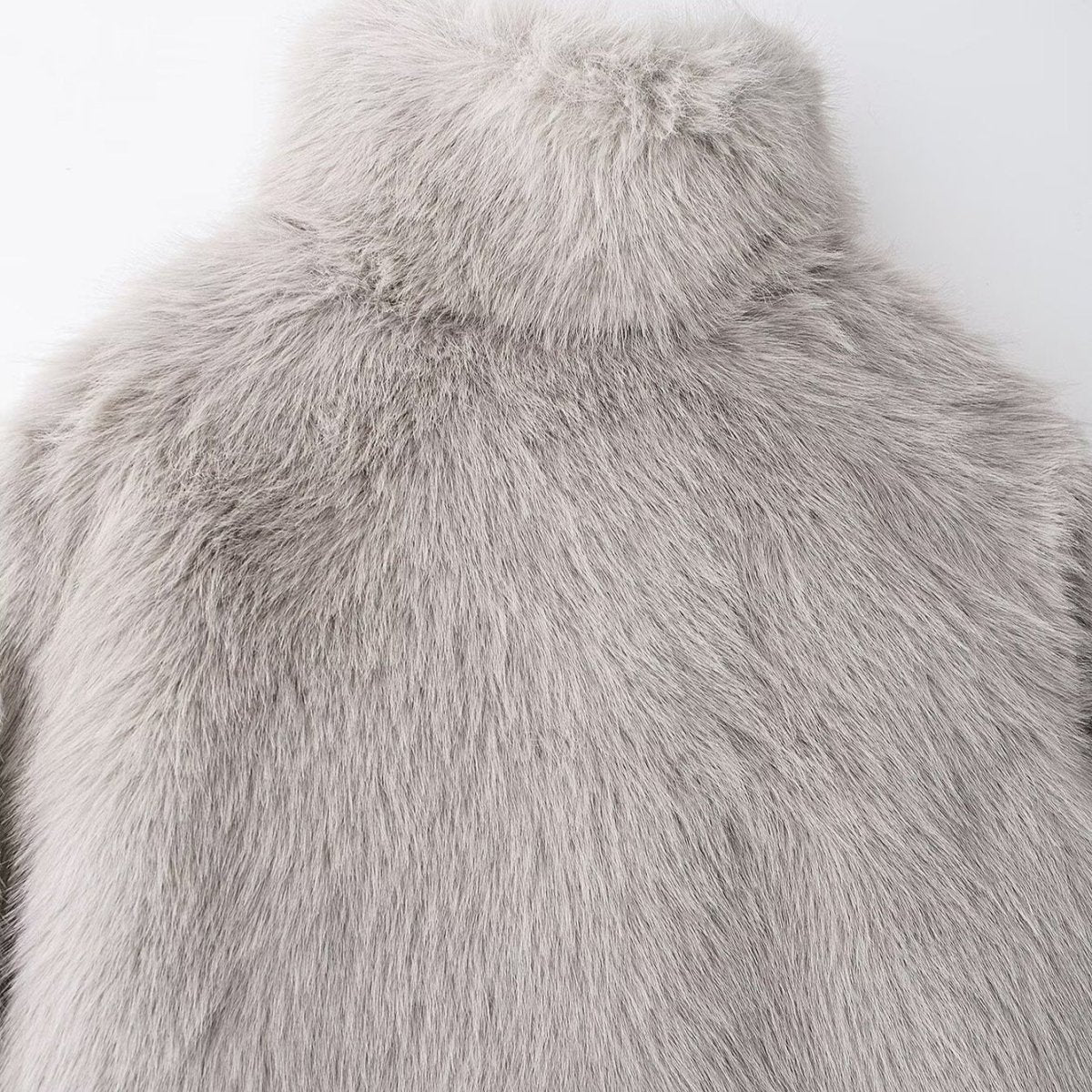Back of the collar and shoulders of the light grey faux fur jacket