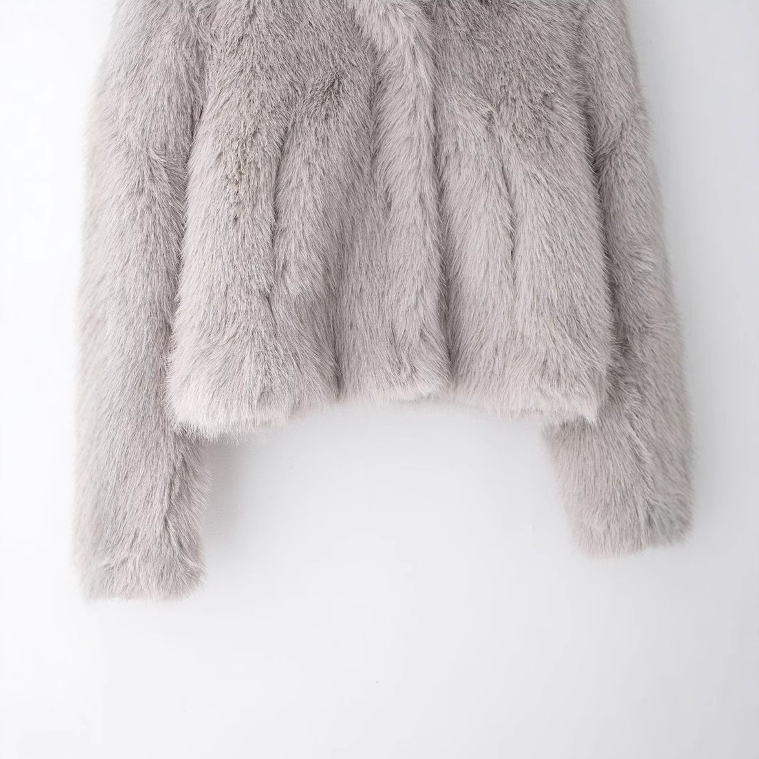 Lower half of the faux fur jacket showing the straight hem and long sleeves