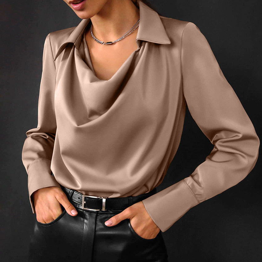 Cowl-neck collared satin-look blouse in khaki, front view on model, hands in pockets, paired with black pants and belt