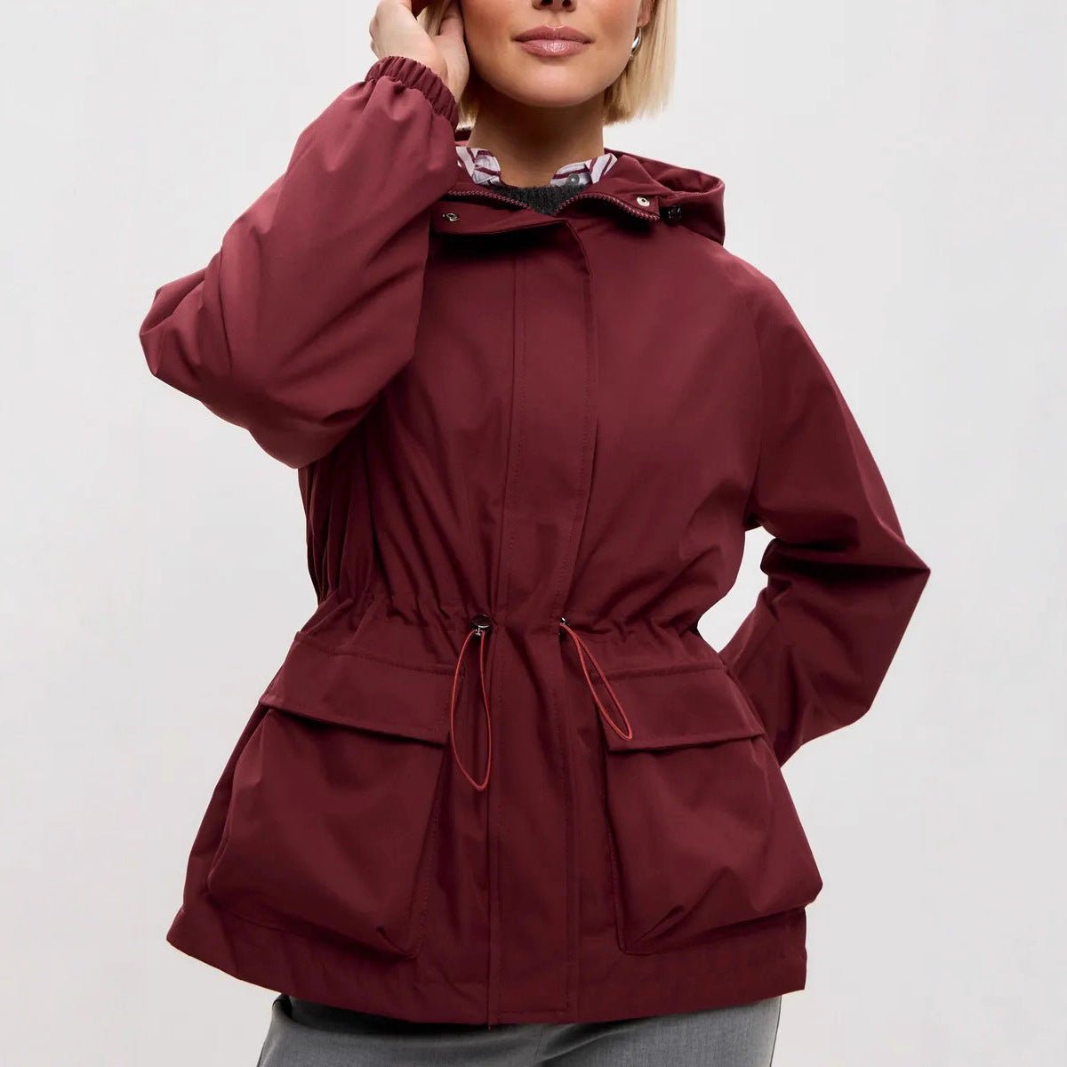 Wine red utility jacket with the drawstring pulled in at the waist