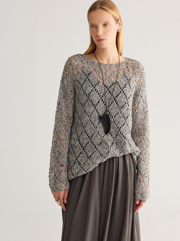 Model in the grey fleck open-knit jumper over a dark grey skirt, front view from head to hip