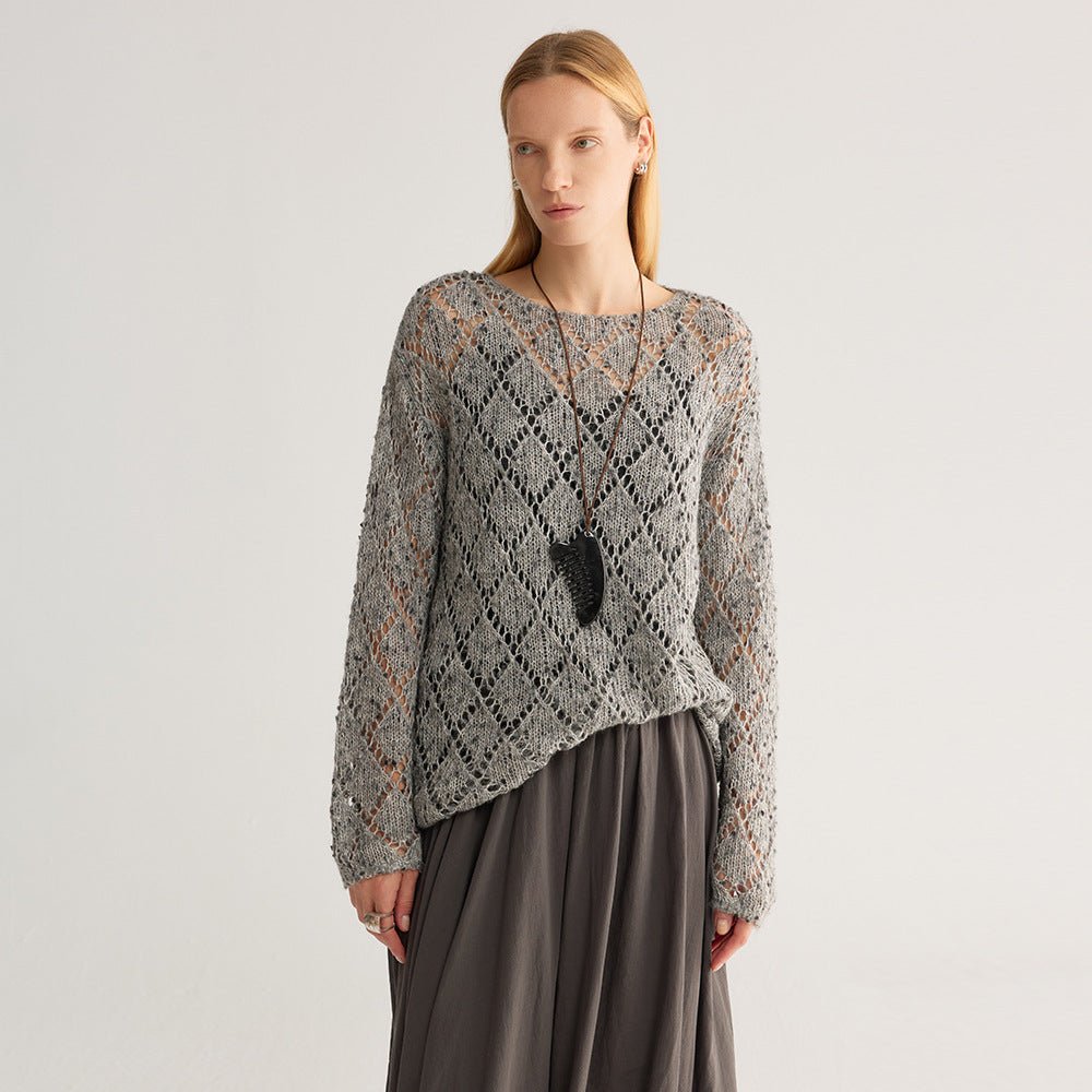 Three-quarter view of the grey fleck diamond-knit jumper, hem draped over a dark skirt