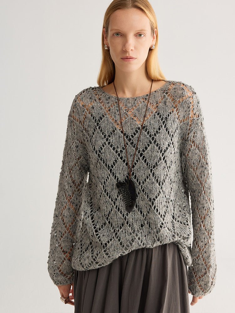 Front view of the grey fleck jumper with a wide round neck, worn over a top, arms down