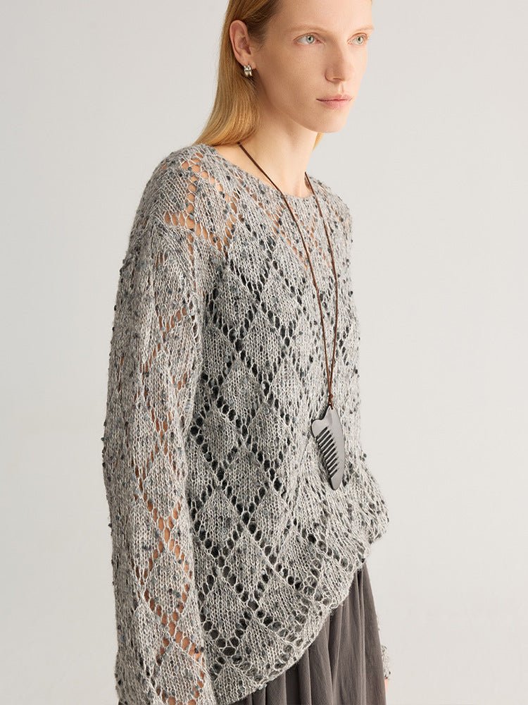 Side view of the grey diamond open-knit jumper showing the dropped shoulder and long sleeve
