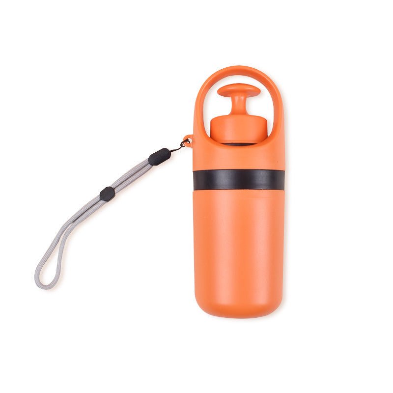 Closed orange dog poop picker with a black band and a grey wrist lanyard