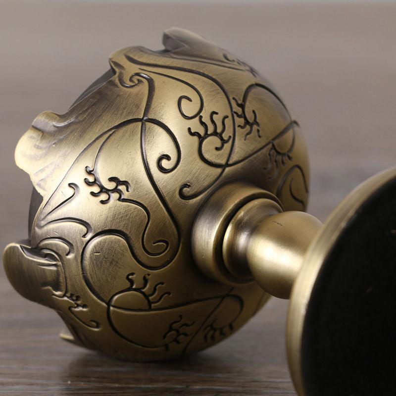 Close-up detail of incense burner side, showing engraved floral patterns and pedestal base