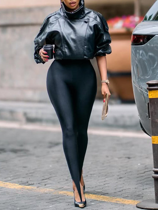 Black faux-leather cropped jacket with puff sleeves, stand collar, worn by model walking on pavement, side view