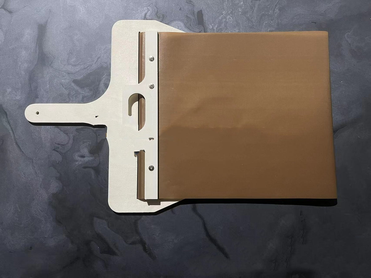 Sliding pizza peel with wooden frame, side view on dark textured surface
