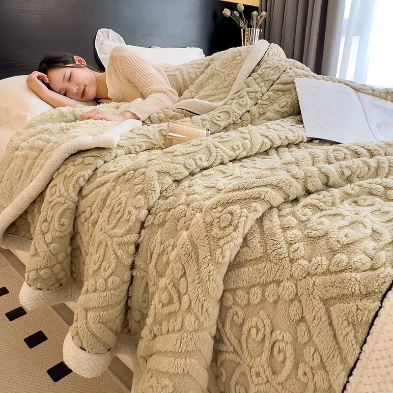 Khaki beige embossed blanket spread over a bed with a person asleep under it