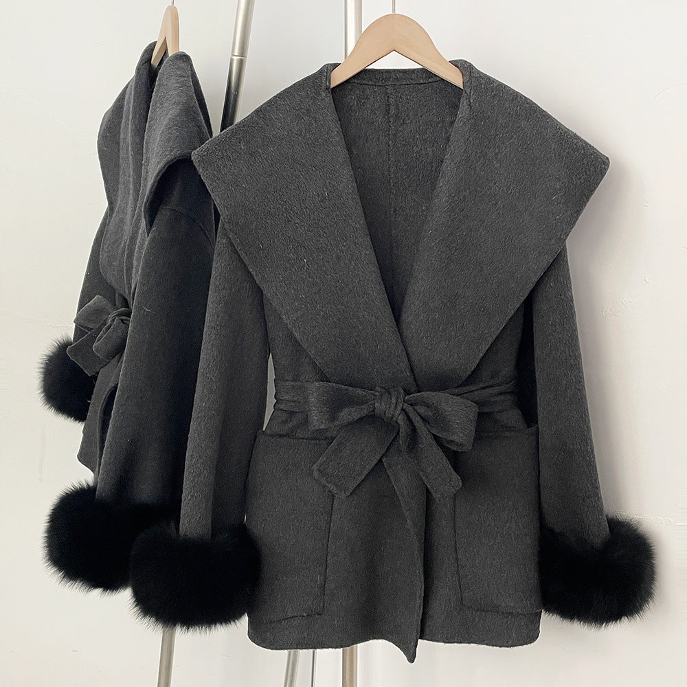Short wrap coat with wide collar and fluffy cuffs in dark grey, front view on hanger