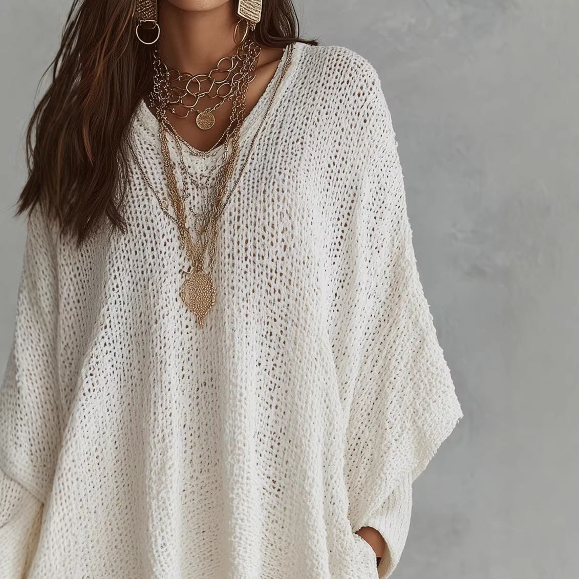 Close-up of white oversized open-knit top, front view on model, showing V-neck and loose knit texture