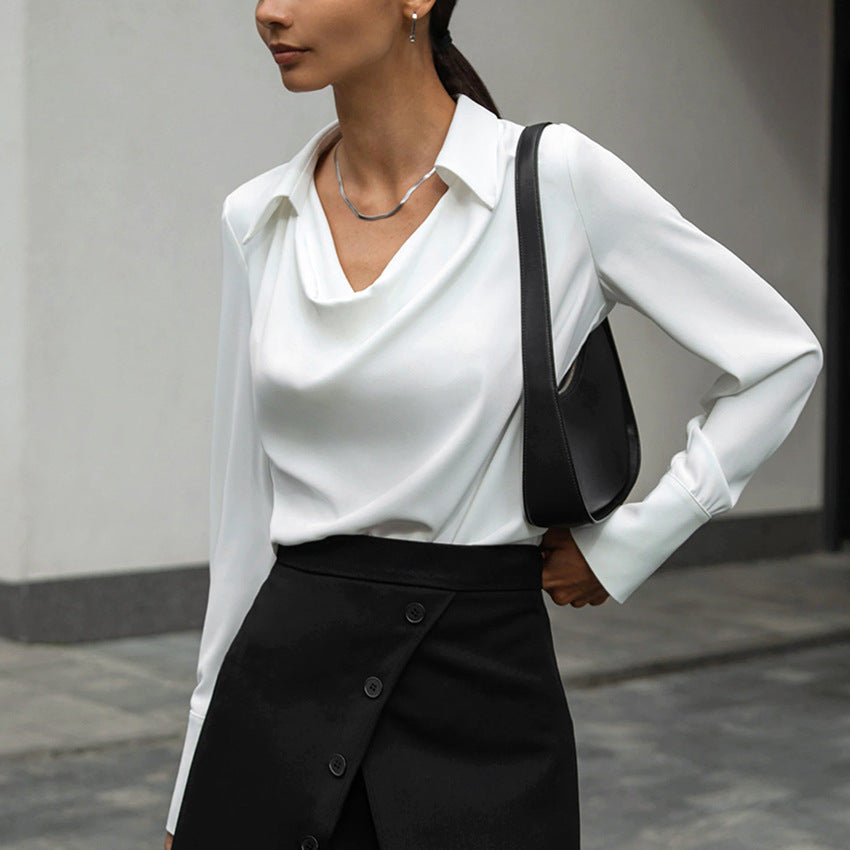 Cowl-neck collared satin-look blouse in white, side front view on model, paired with black skirt and shoulder bag