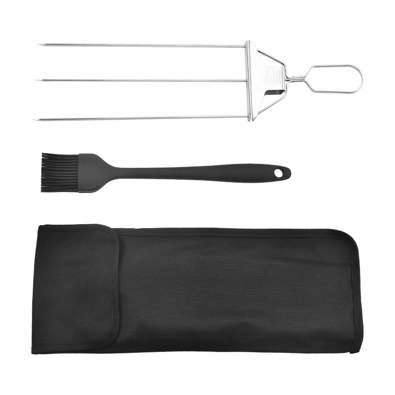 Top-down flat lay of three-prong stainless steel skewer, black silicone brush, and black fabric storage bag on a white