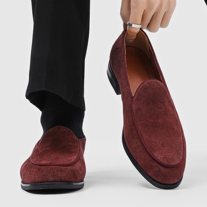 Burgundy suede-look men's slip-on loafer, worn on a foot with a black sock, second loafer held next to it