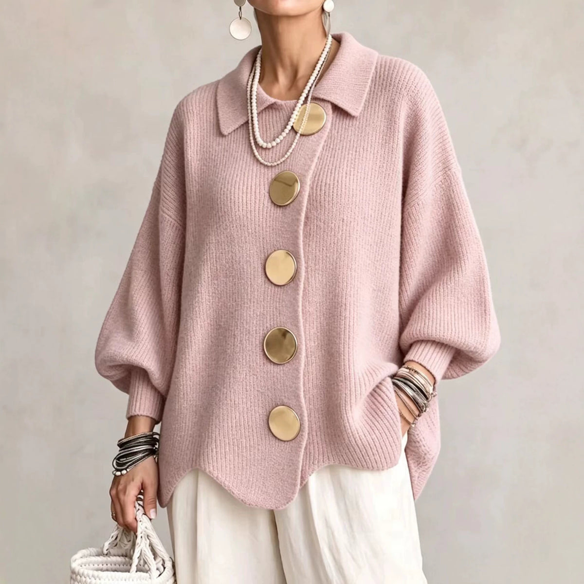 Collared knit cardigan in pink with large gold buttons, worn on a model, front view, wavy hem, dropped shoulders