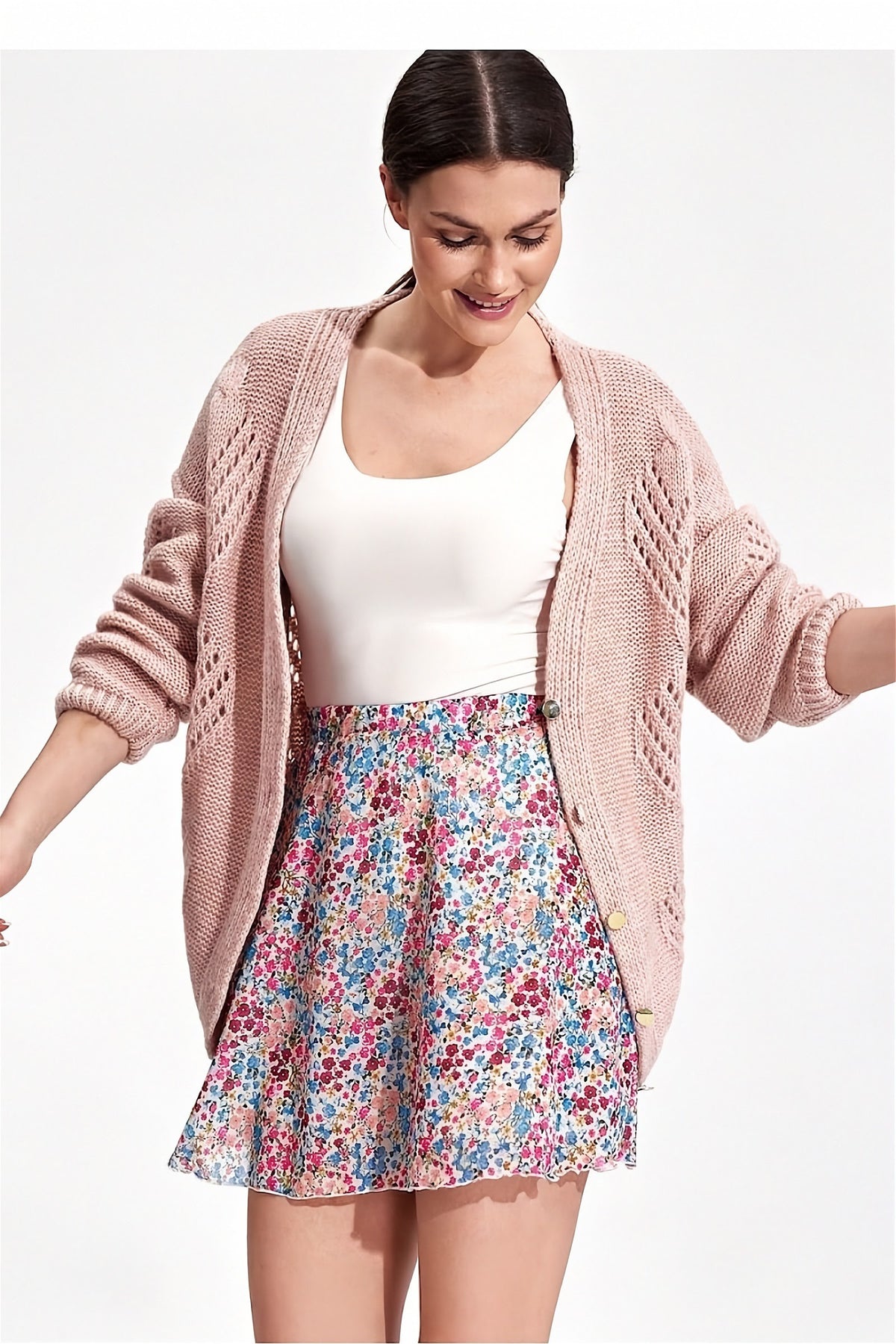 Pastel floral flared mini skirt by Figl with lining and elastic waist, front view with a pink cardigan