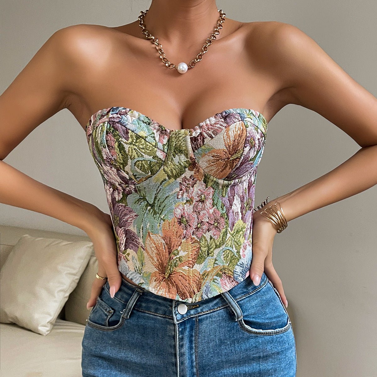 Lily-print strapless top with pointed front hem, hands on hips