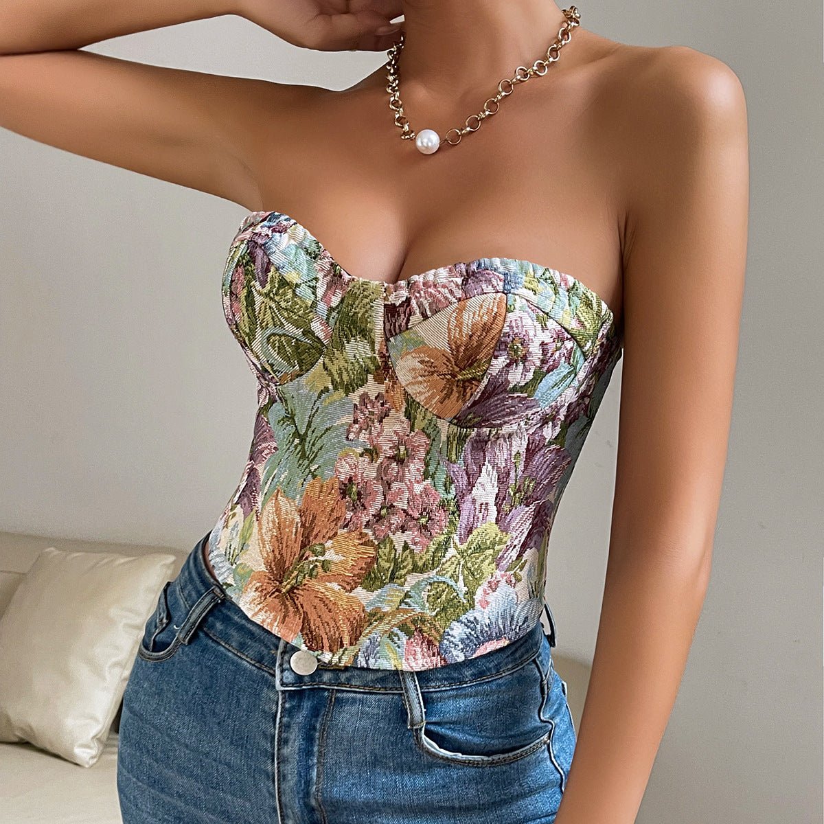 Light floral corset top with large lilies, worn with blue jeans and a chain necklace