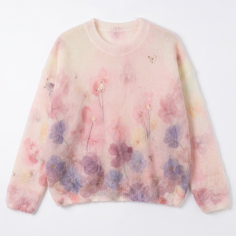 Pink misty floral jumper laid flat, pale pink with purple flowers along the hem