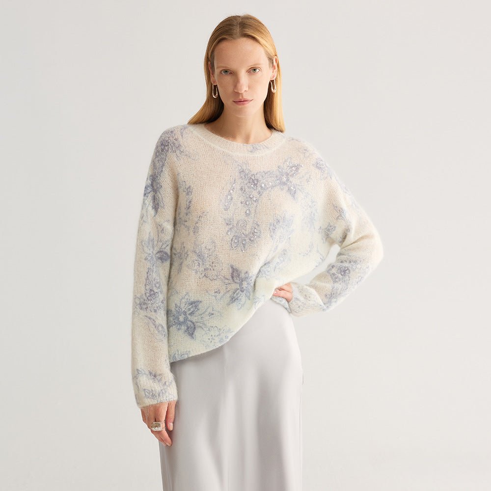 Wider shot of the blue floral jumper on ivory with a long grey skirt
