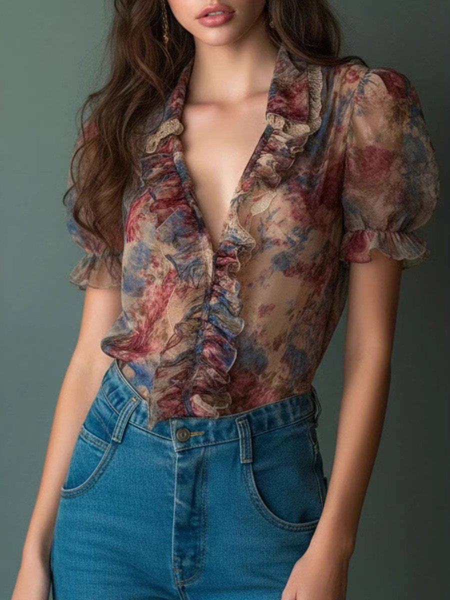 Floral print blouse with ruffled neckline and flowing sleeves on a model wearing light blue tones