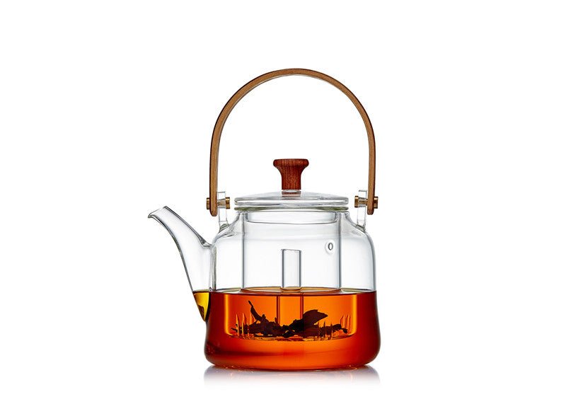 Glass teapot with wooden handle and lid knob, front view, partially filled with tea, white background