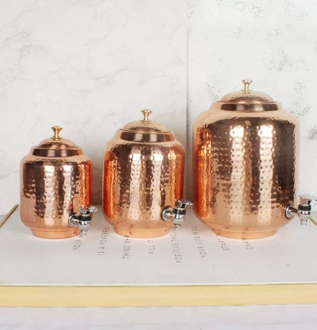 Hammered copper-look water dispensers with tap, three sizes side by side on a flat surface with text background