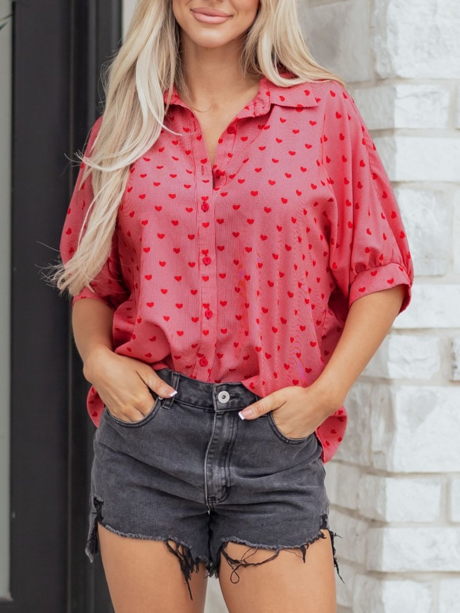 Woman model wearing heart print button-down shirt with soft cotton blend fabric and relaxed fit silhouette