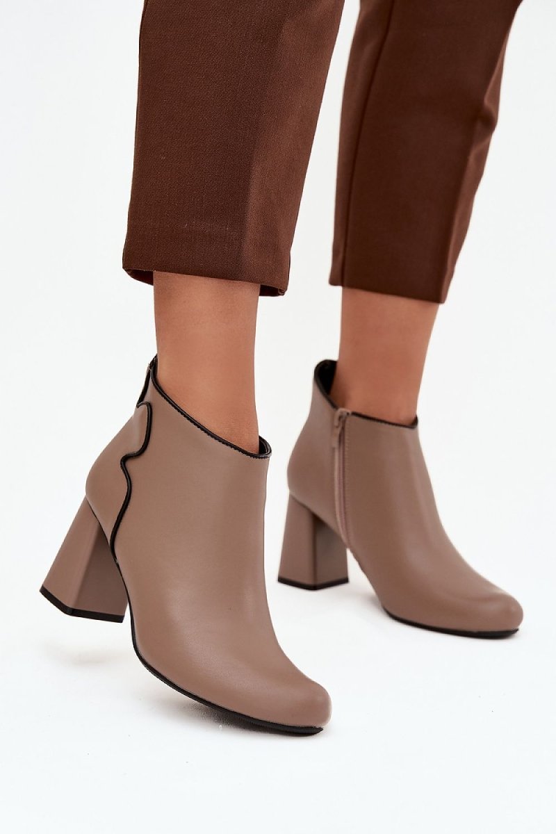 Beige heel ankle boots on a woman’s foot, Step In Style waterproof winter boots, stylish fall footwear