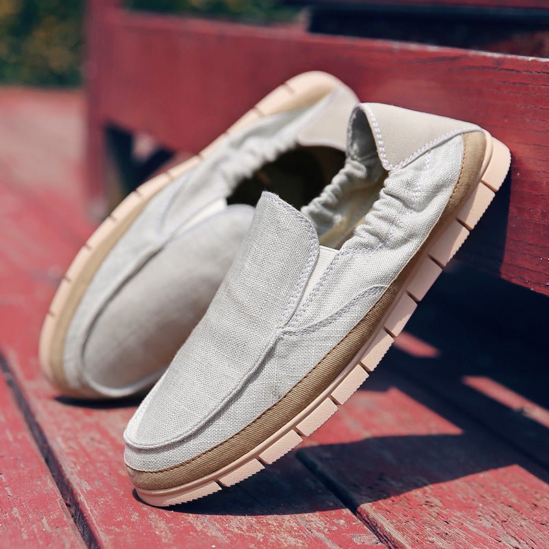 Linen-canvas slip-on loafer in white, flat lay on red wooden bench, side view