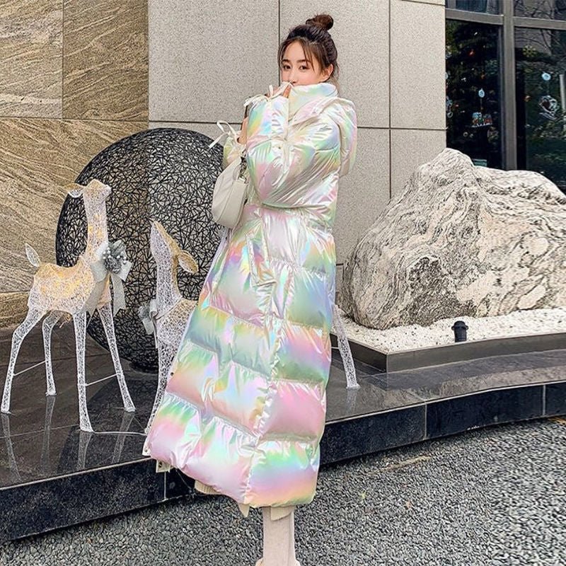 White iridescent puffer coat worn outdoors next to a rock and deer figures