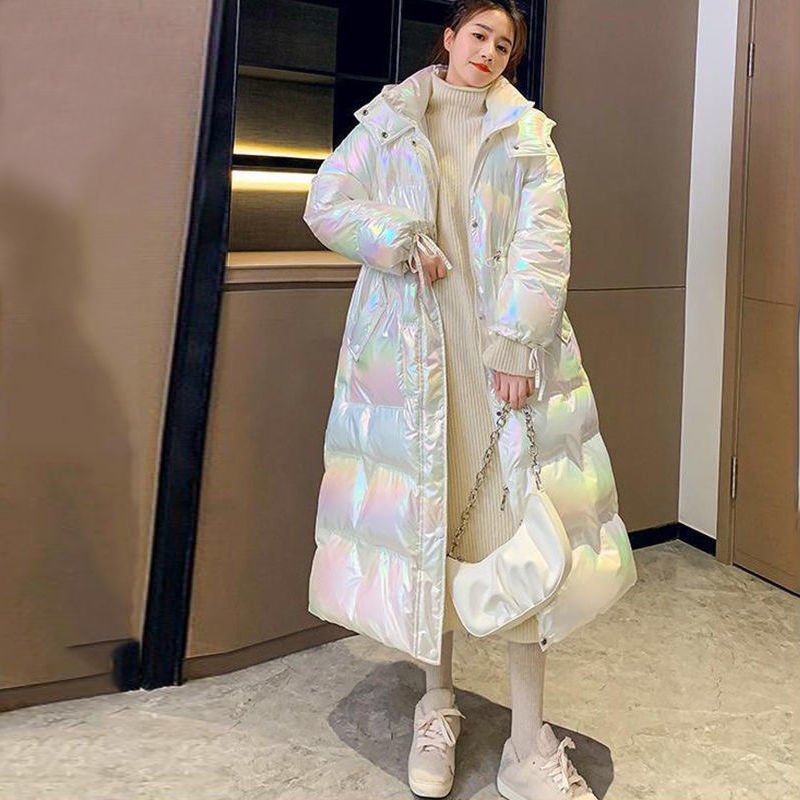 White puffer coat with a drawstring at the waist and a hood, worn with white trainers
