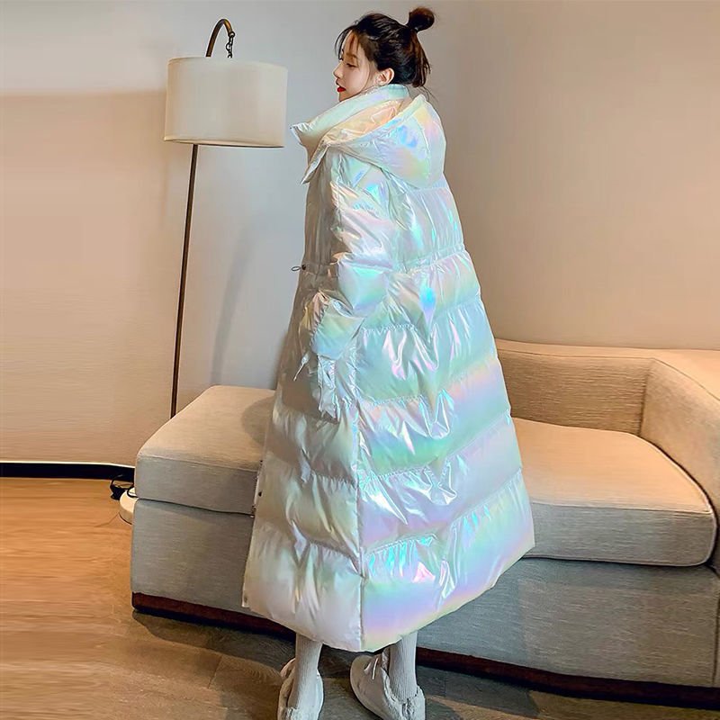 Side view of the white puffer coat falling to the lower calf, next to a sofa