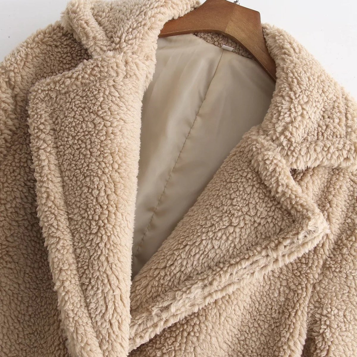 Close-up of the curly teddy lapel and the smooth beige lining