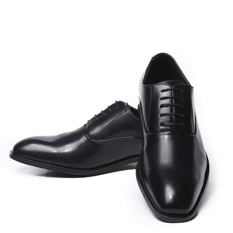 Black men's oxford shoes in polished faux leather, one resting on the other