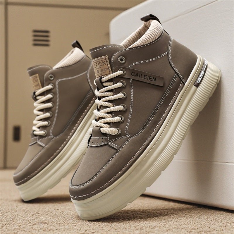 Brown high-top lace-up sneaker boots with thick cream sole, leaning on a white wall