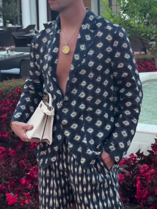 Navy printed co-ord set worn open over a bare chest, one hand in the shorts pocket